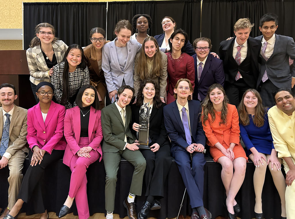 A group of 20 students face the camera and smile.
