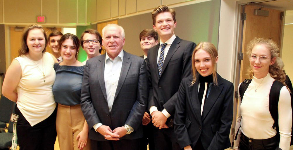 John O. Brennan standing with a group of Schar School undergraduate students