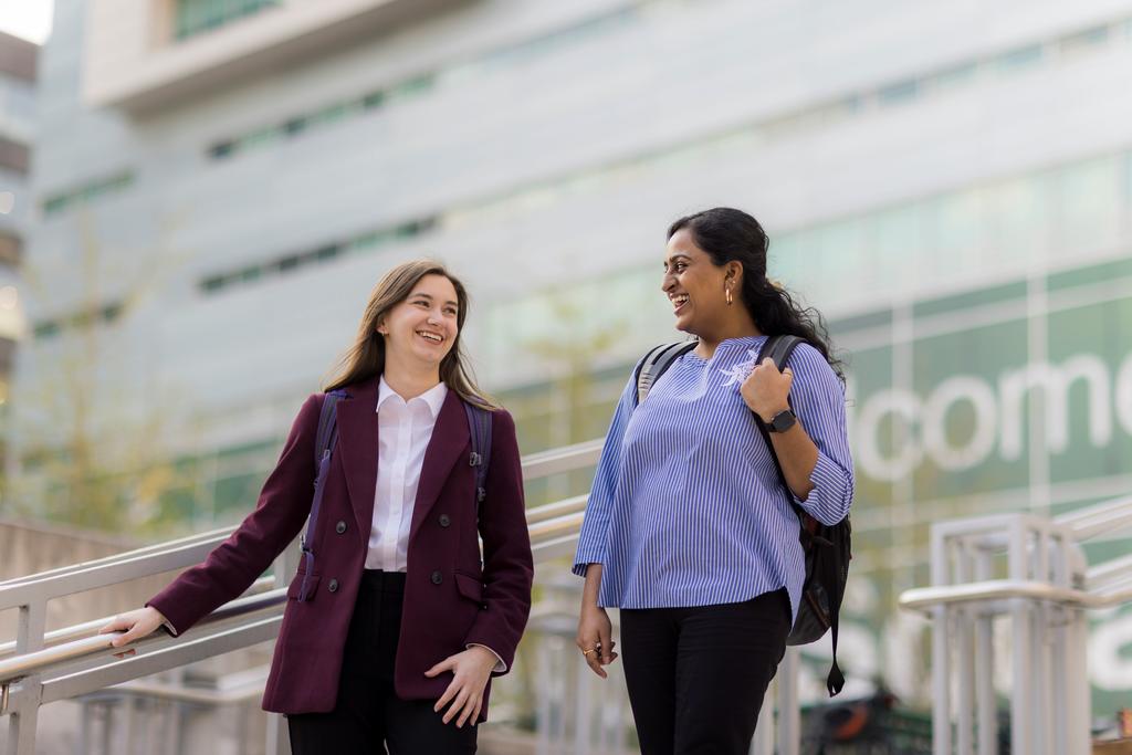 Two graduate students talking on the plaza