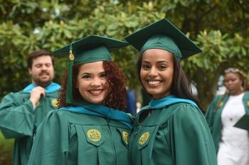 Graduating Schar School students in green caps and gowns