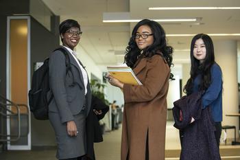 Three women standing in a building and smiling