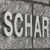 A photo of the text SCHAR on a concrete block wall.